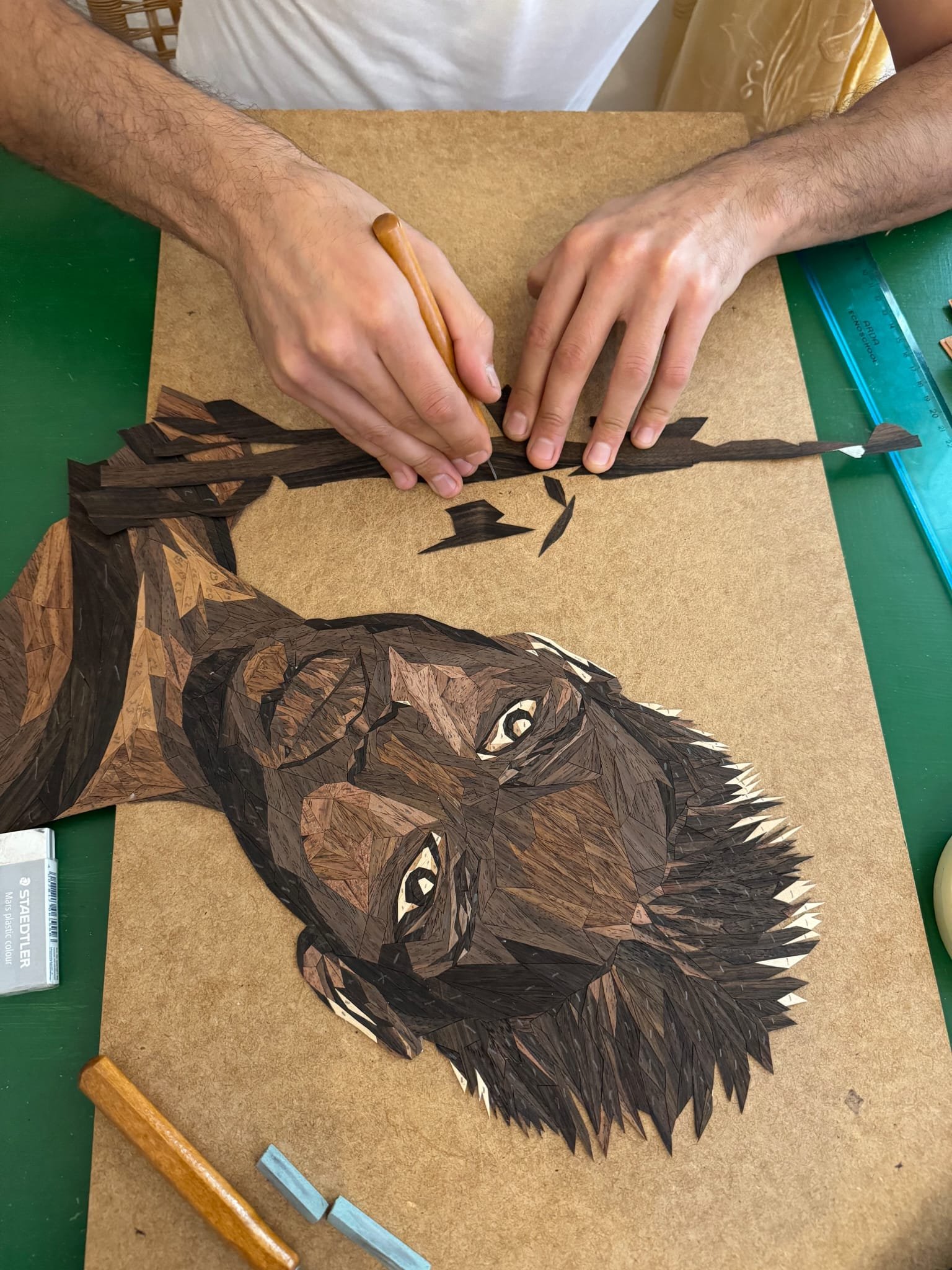 Detail of marquetry veneer pieces being arranged